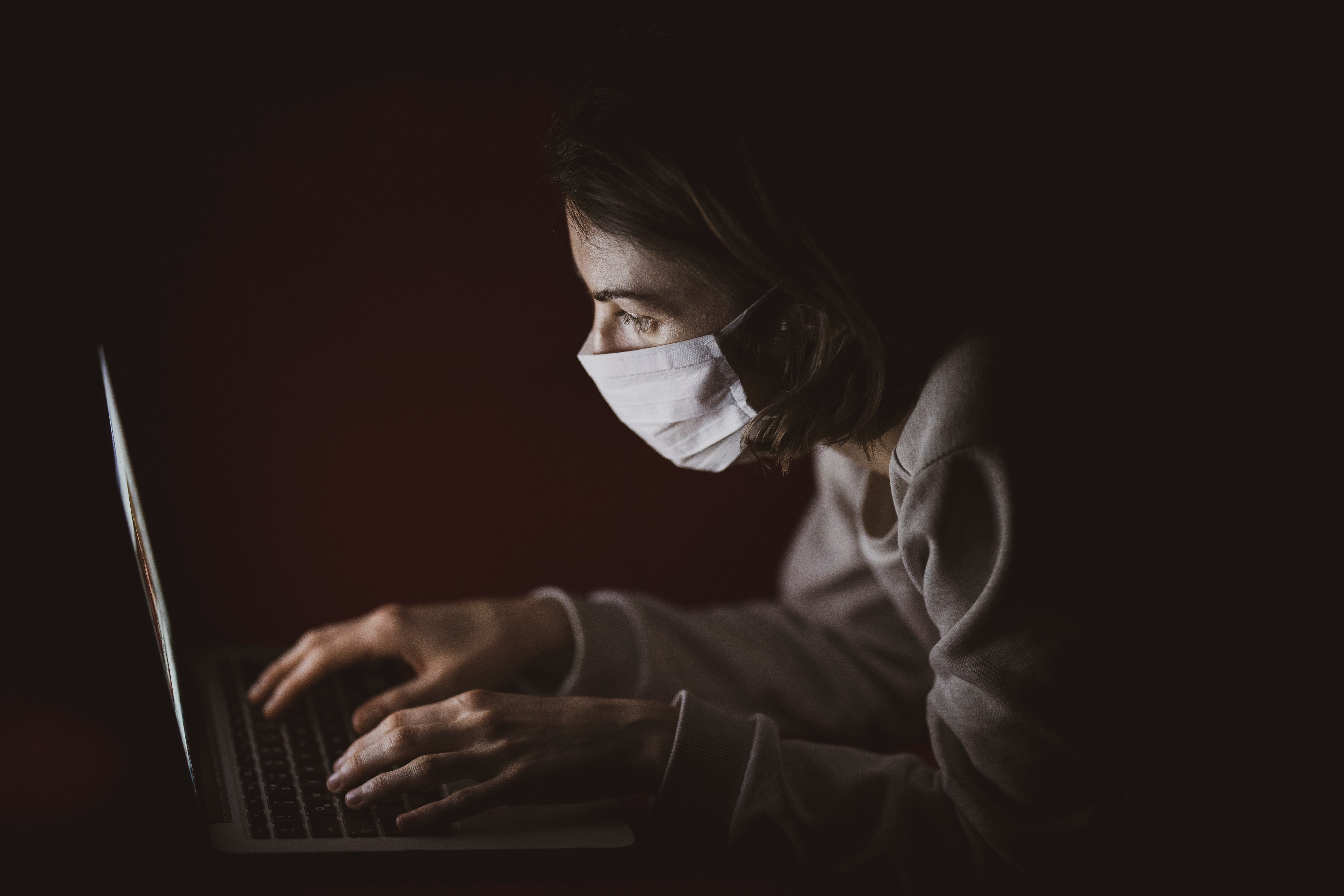 Masked woman on a computer