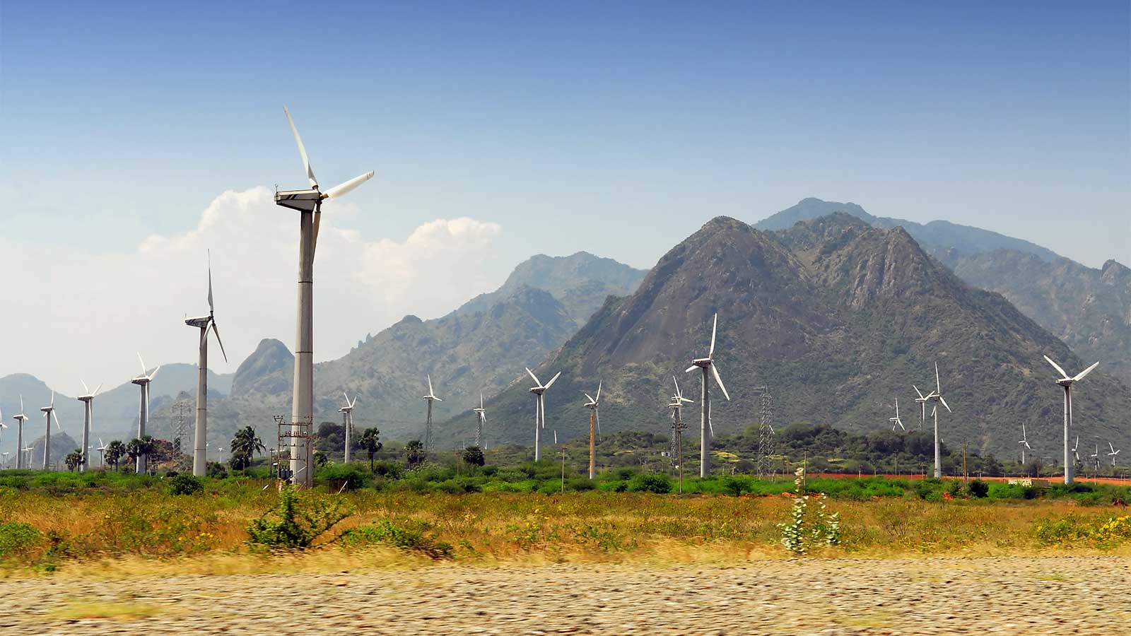 Wind turbines with a hilly landscape in the background.