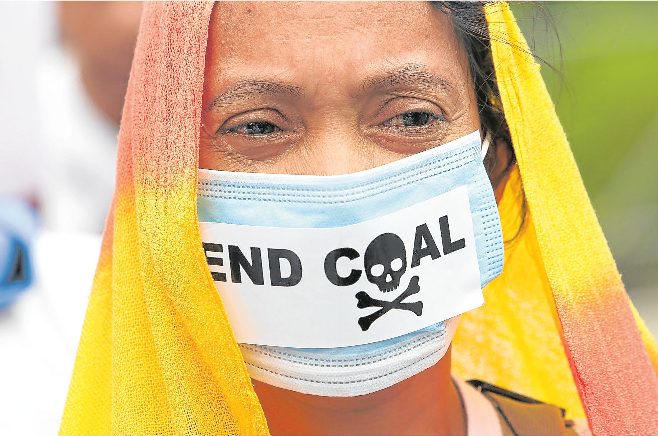 Woman in mask calling to end coal. 