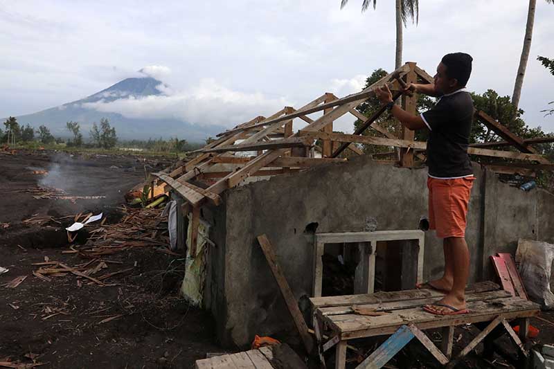 man fixing his house battered by typhoon