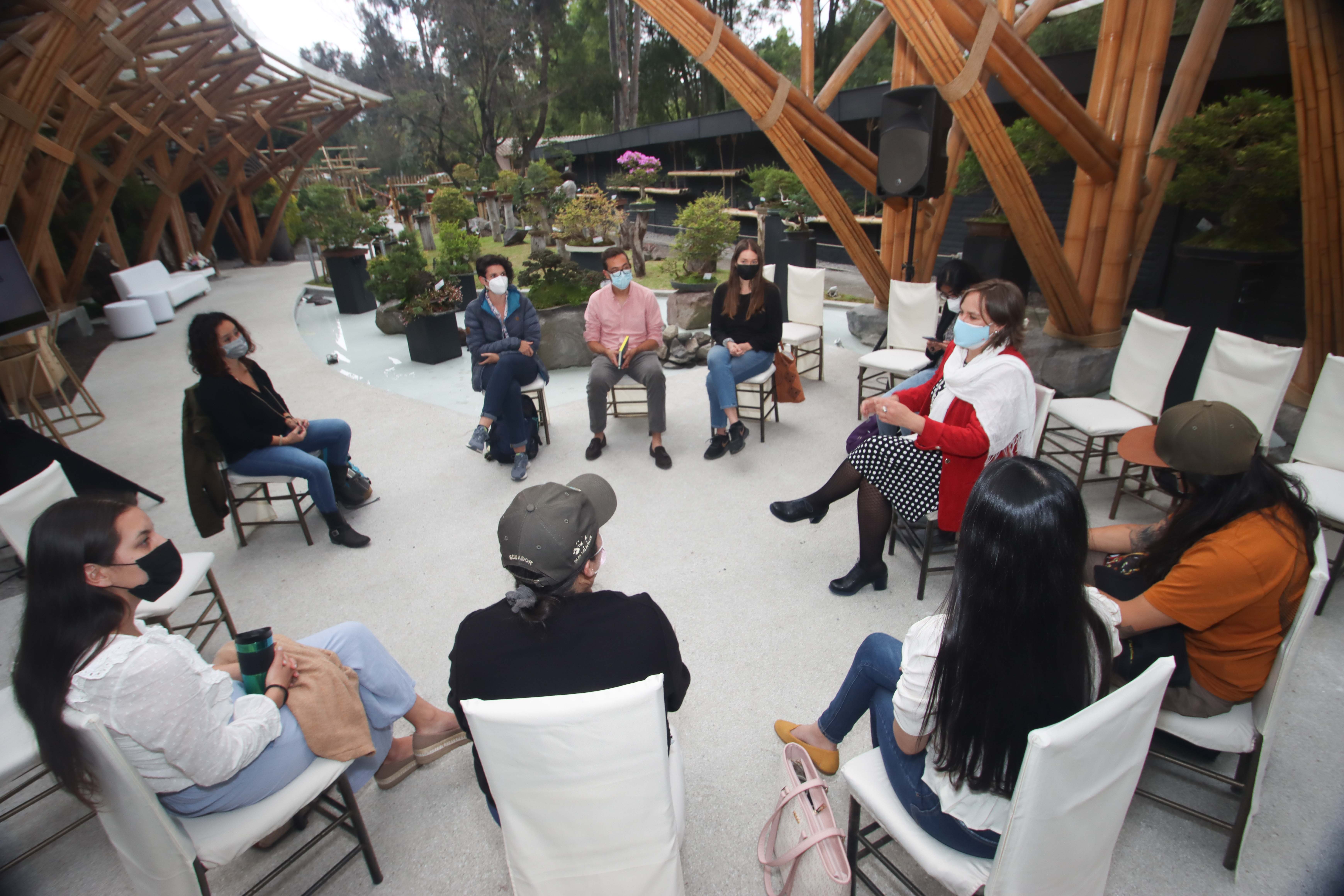 Seated journalists gathered in a circle outdoors