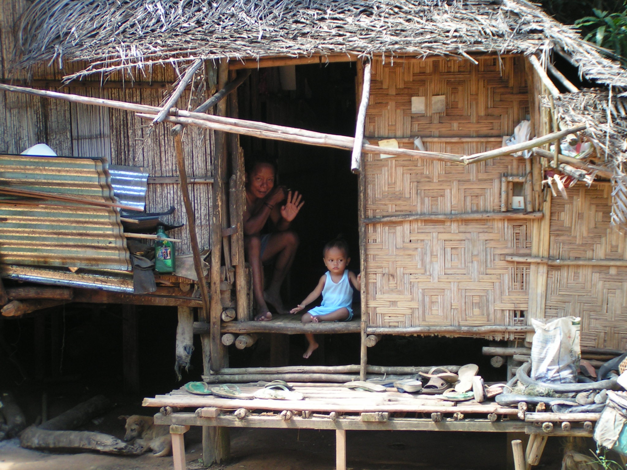 a woman and child inside a thatched hut