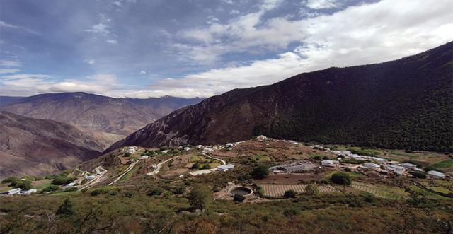 a view of naren village, a town on a hill with mountains behind it