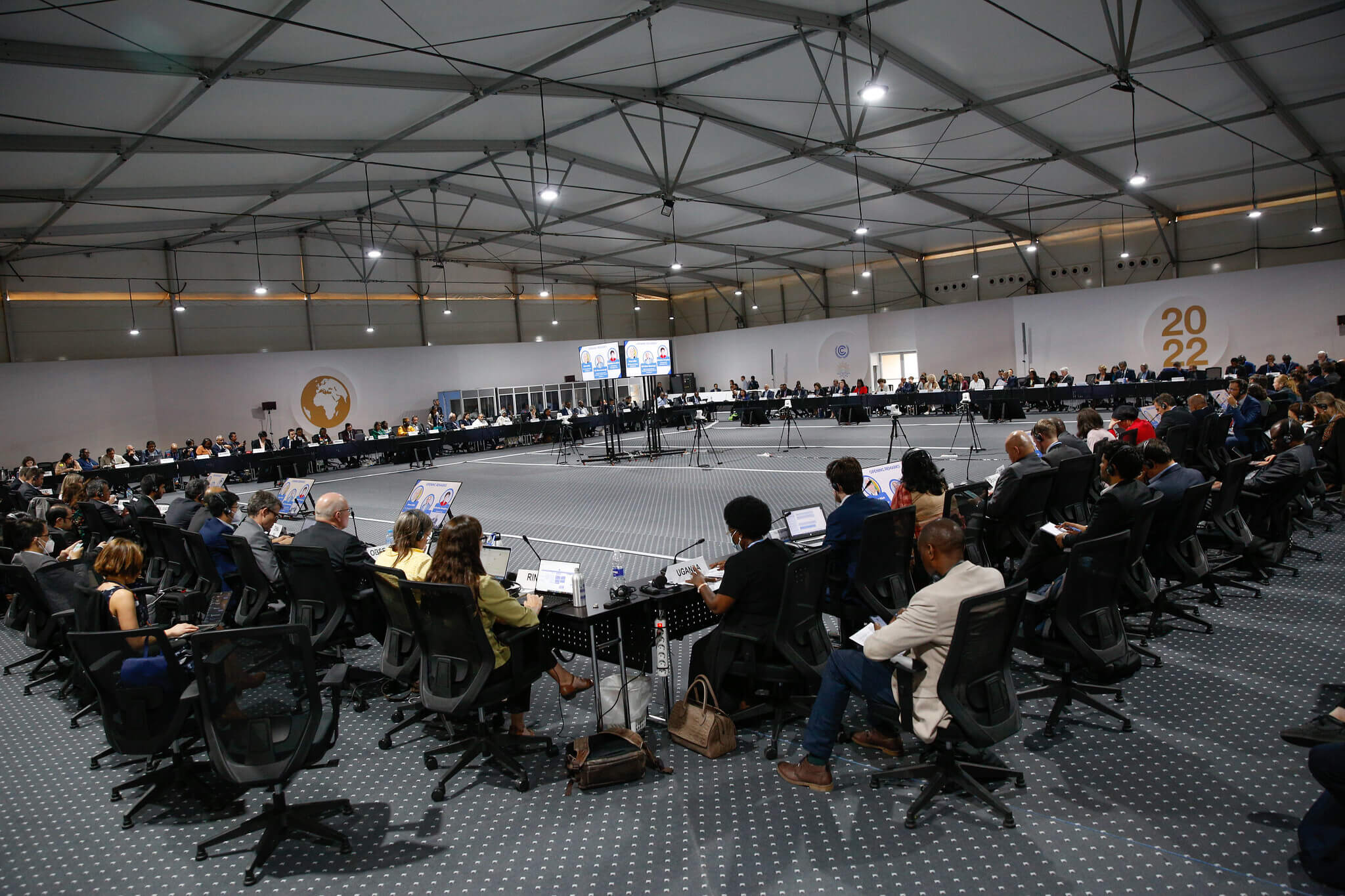 a large, brightly lit conference room full of people sitting in chairs