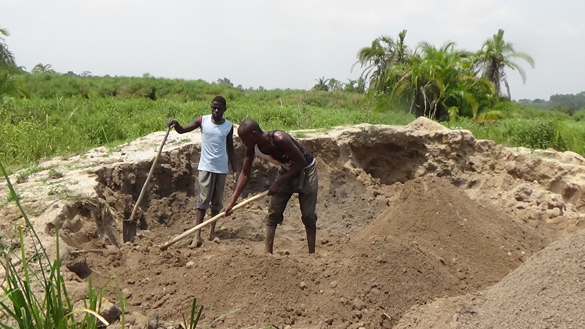 sand miners digging a pit in a wetland