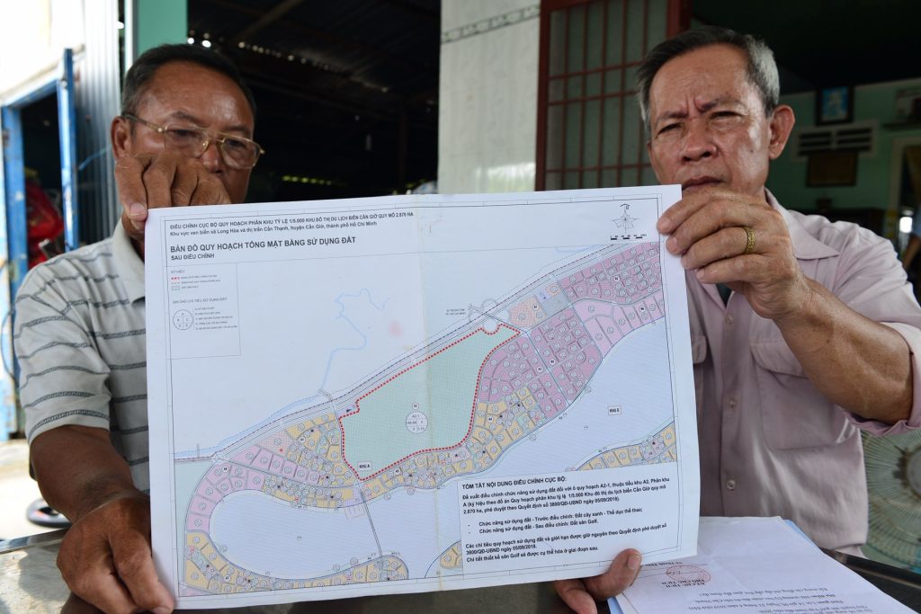 Locals holding a map of the project