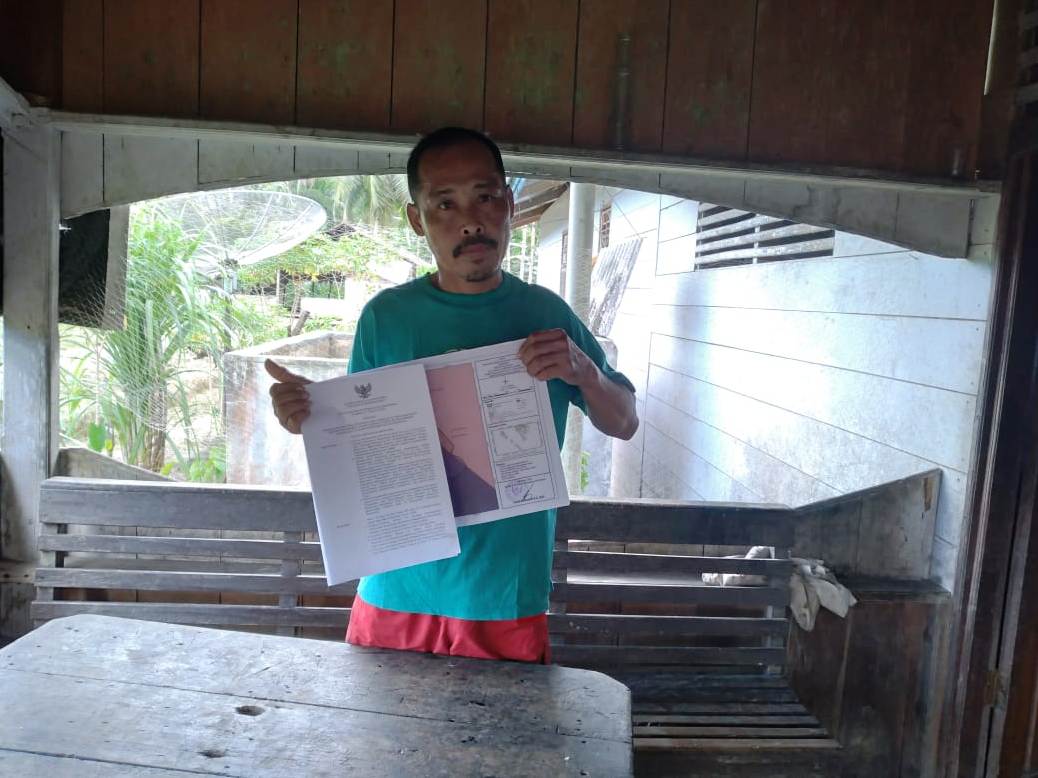 a man holds up an official document