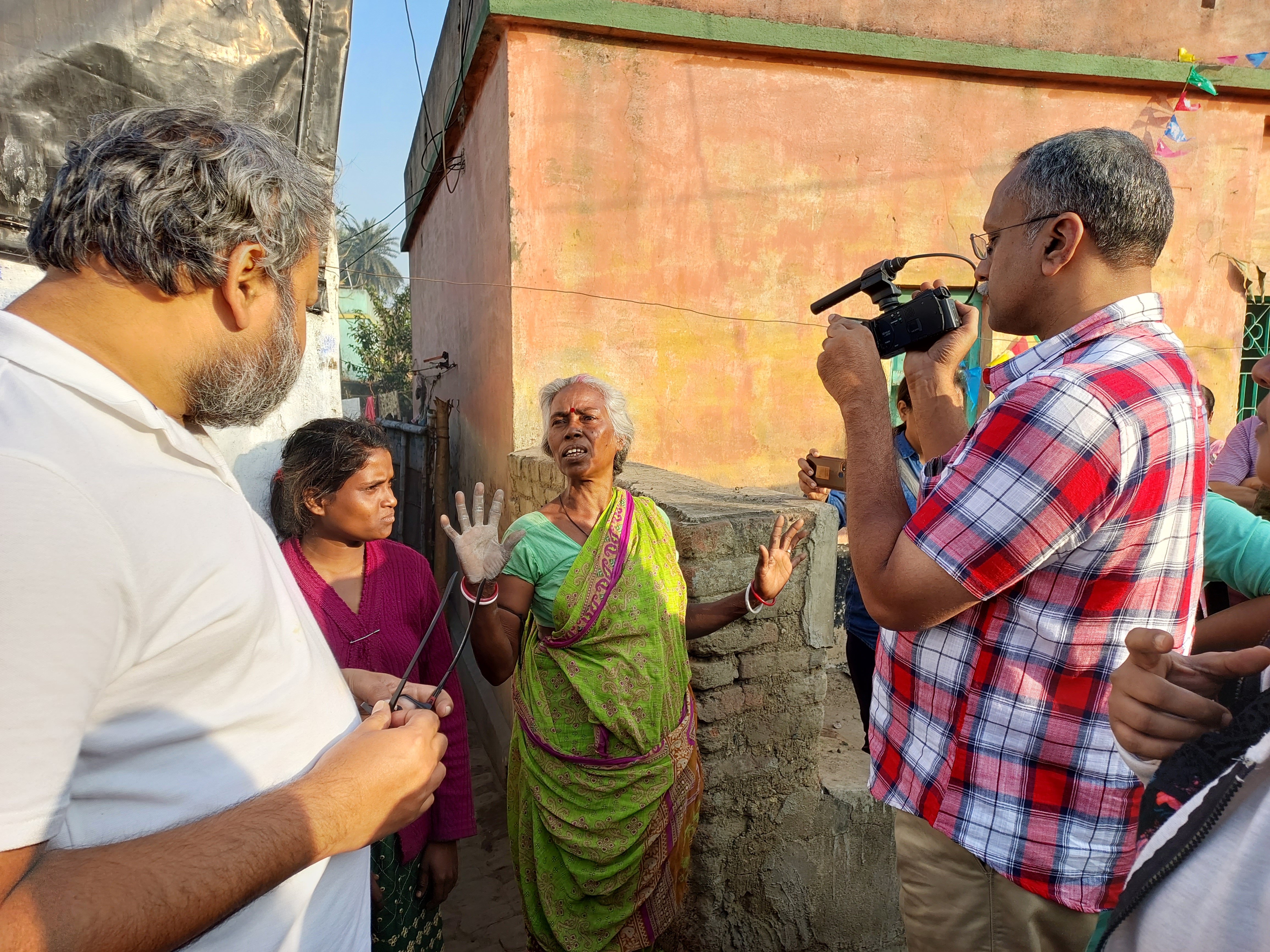 A woman gestures as a man films her