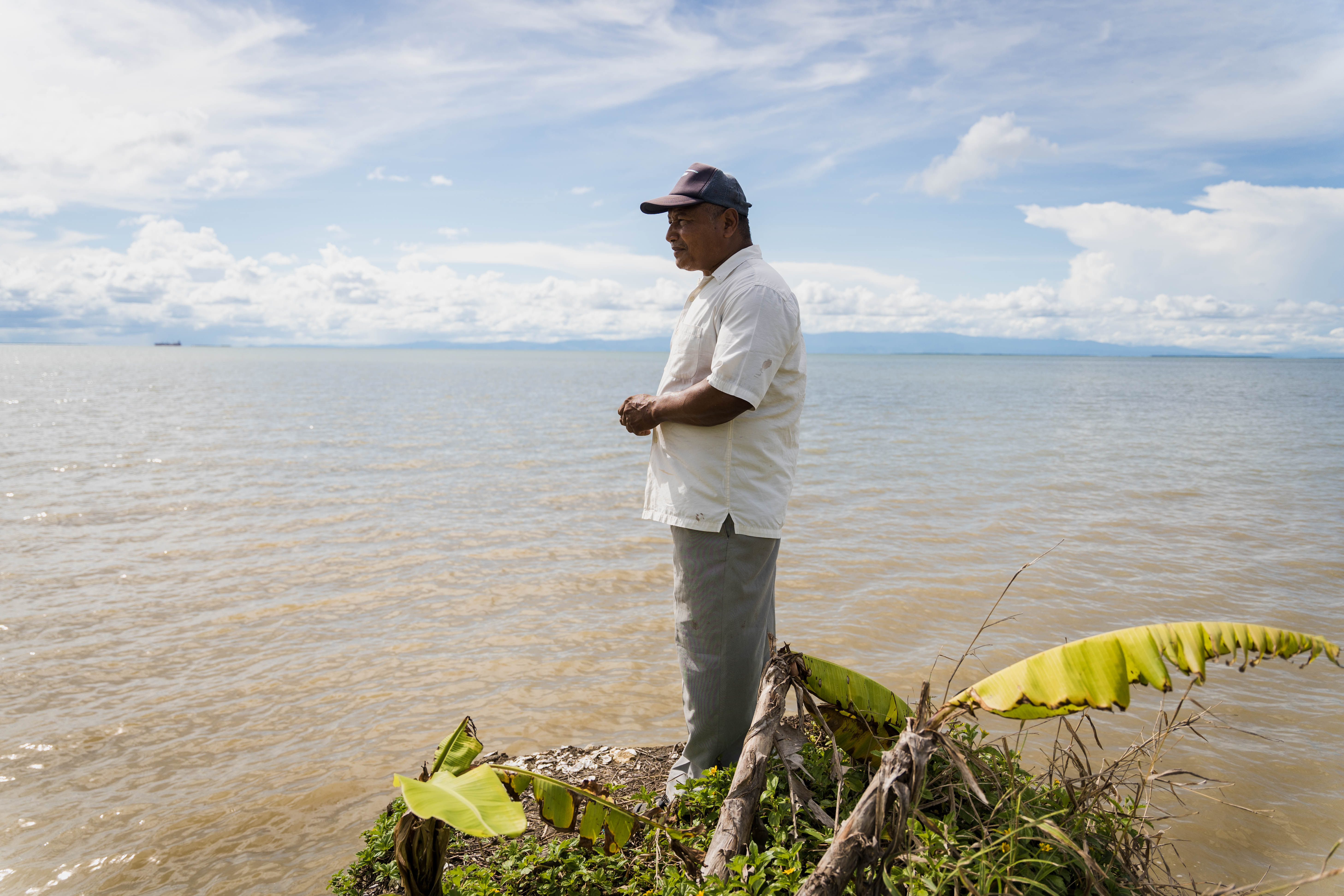 Ángel Montalbo, resident of Punta Coquitos, next to a banana palm affected by the coastal erosion. / María Camila Morales - El Espectador.