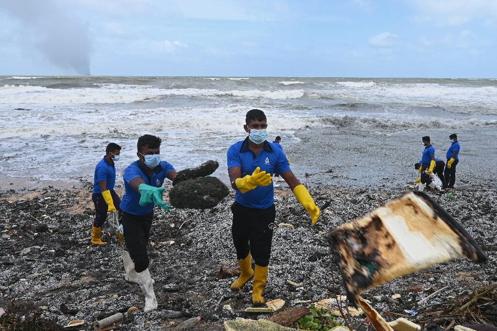 Workers collecting debris strewn on the beach