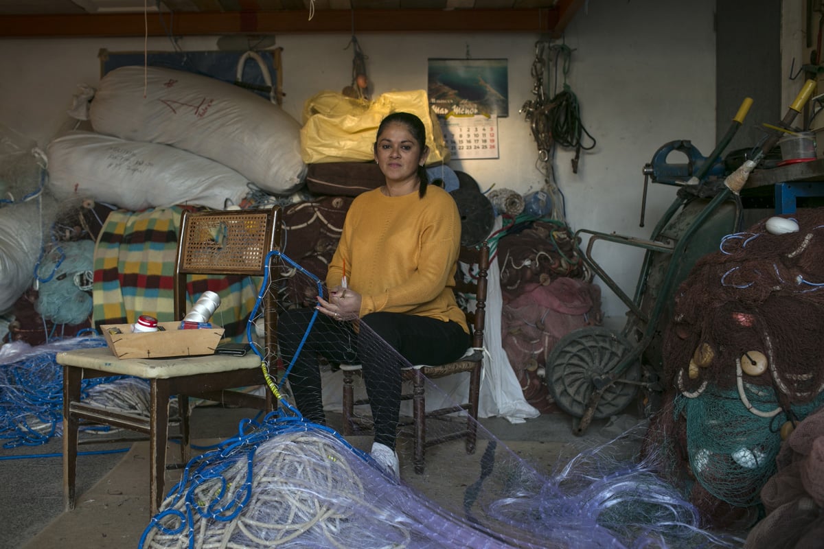 A woman fixing a net in a garage 