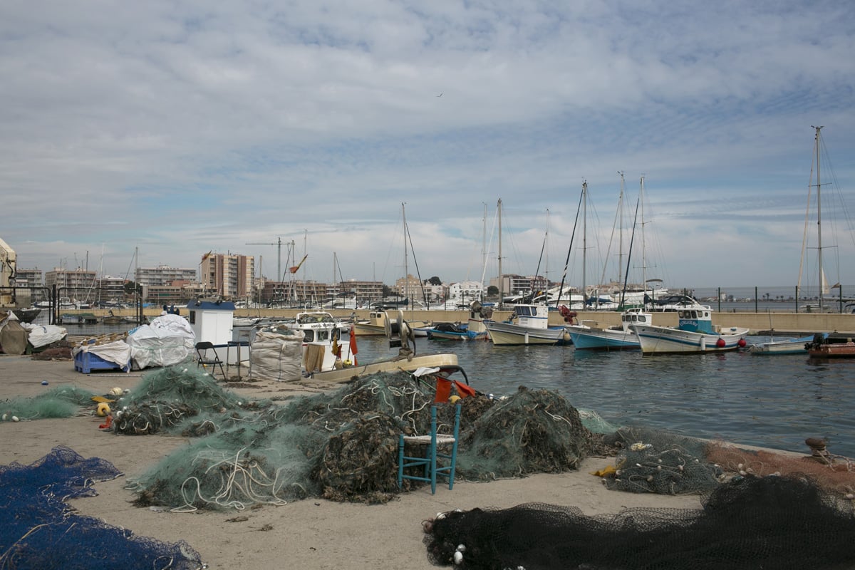 Docked boats and fishing nets full of dried seaweed in the port of Lo Pagán, north of the Mar Menor.