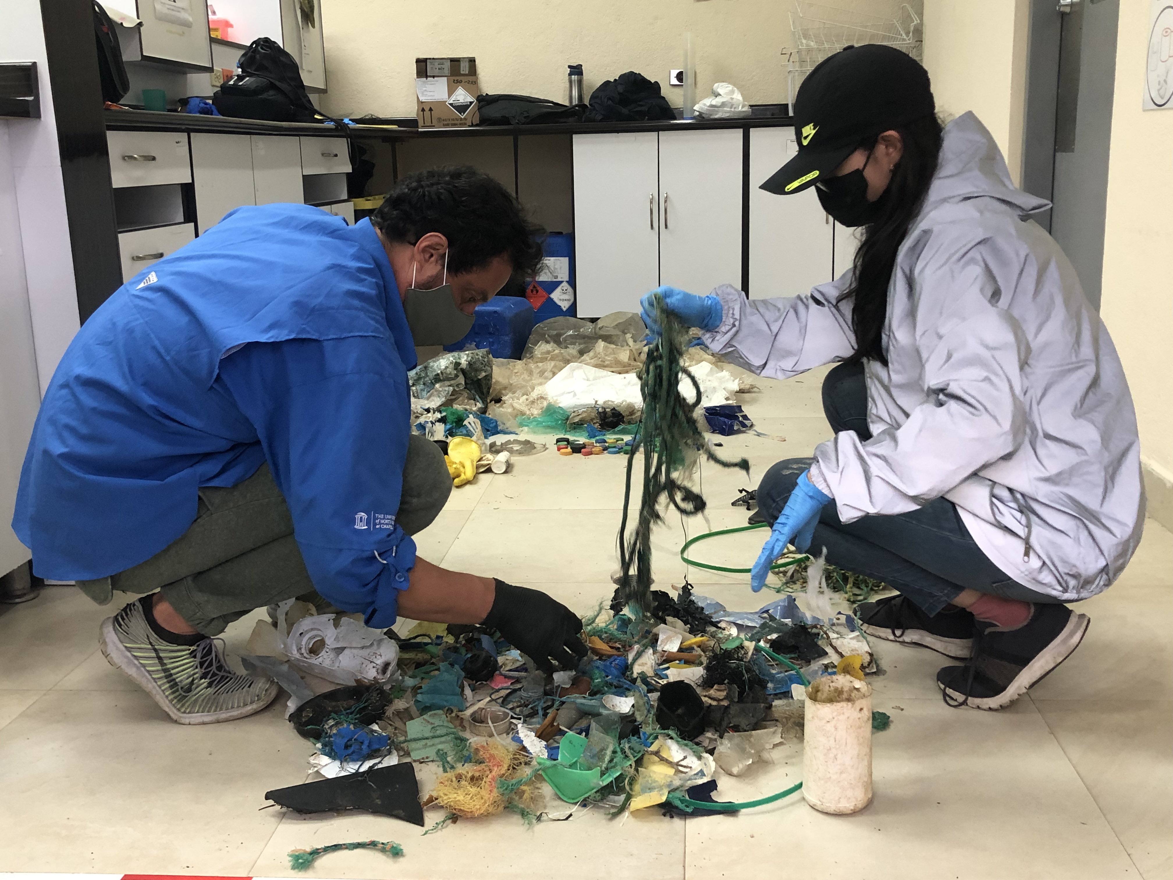 scientists sort through collected trash