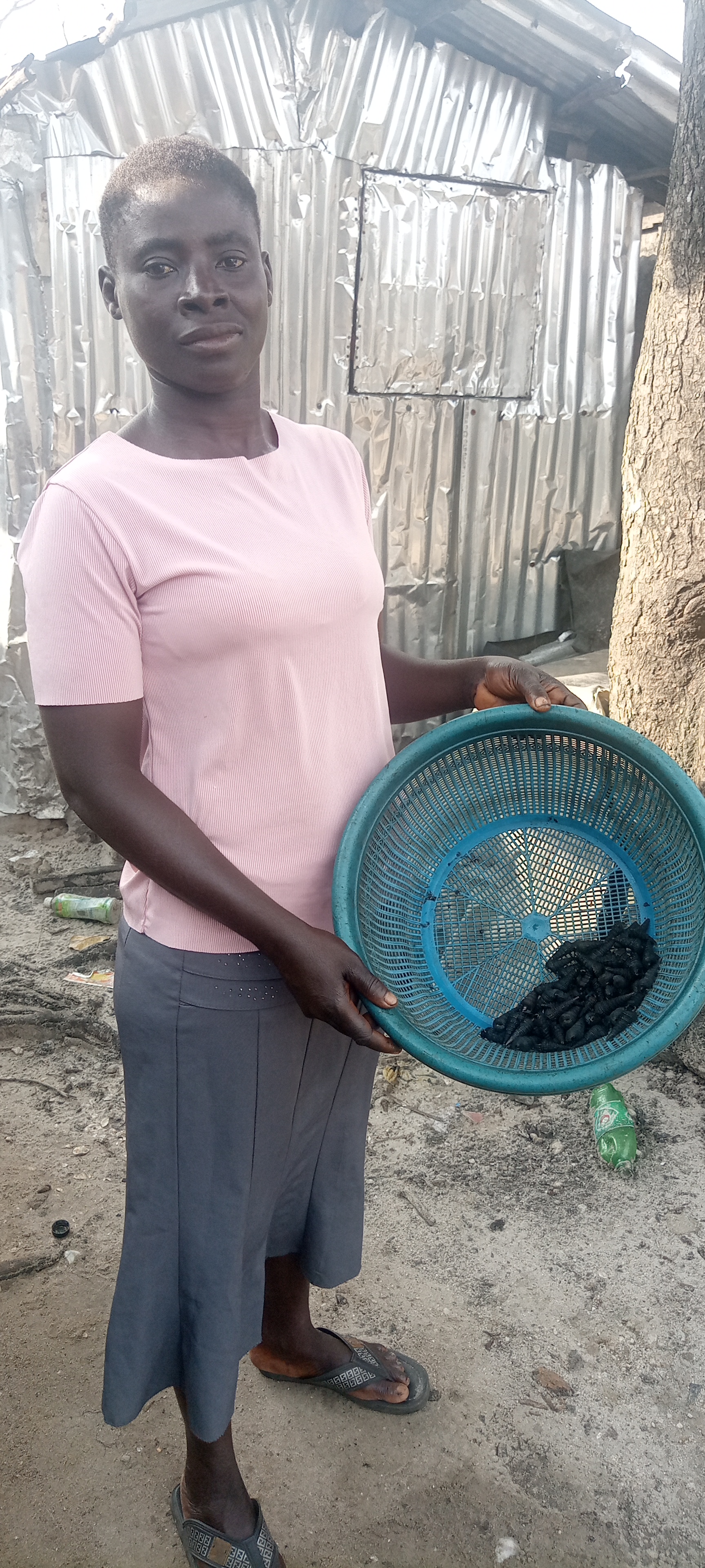 Loretta holding periwinkles she and her sister caught from the Creek of Alakiri after spending hours. Photo Credit: Elfredah Kevin-Alerechi