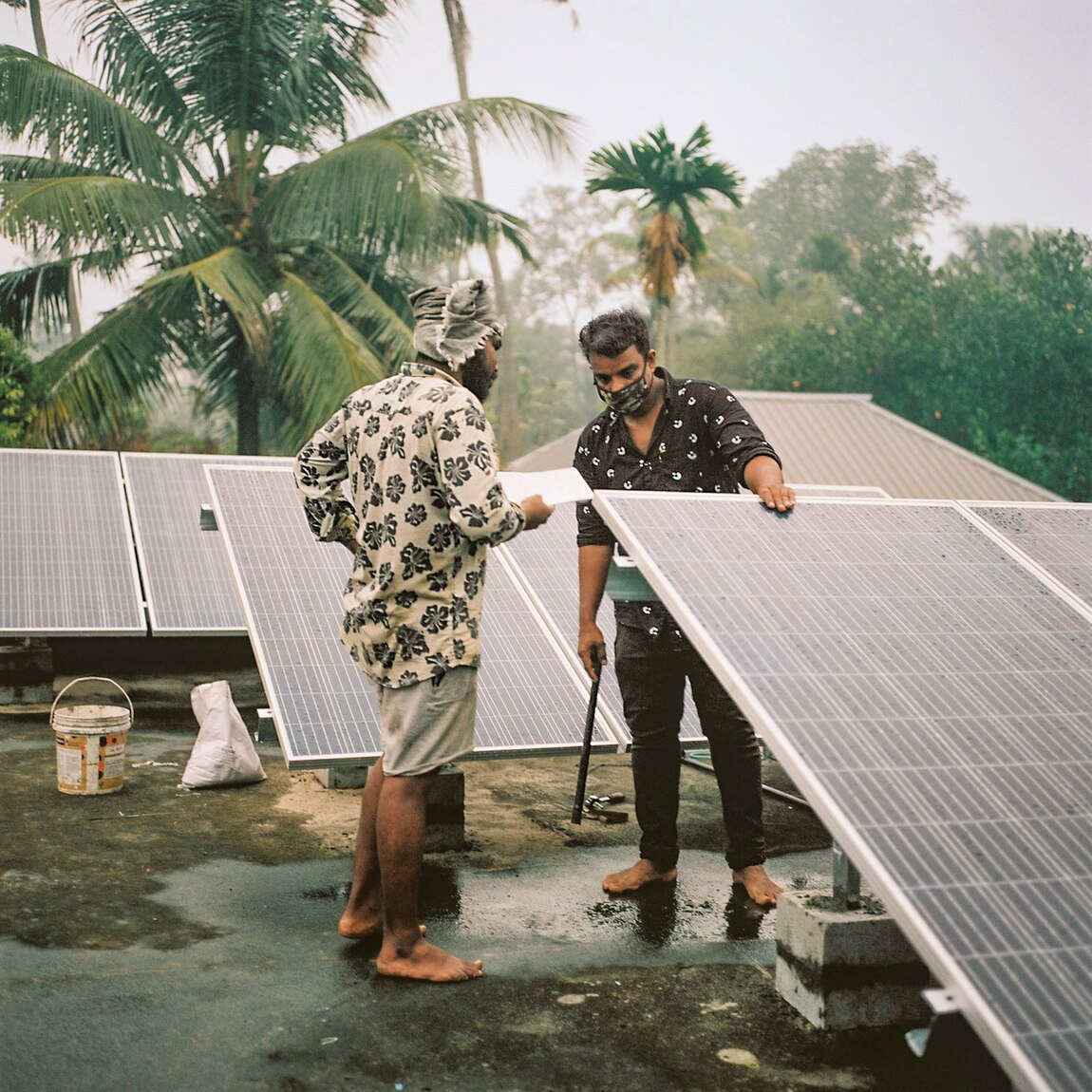 Employees of Tharayil Power, a solar energy company, install solar panels on the roof of a house in Kerala.