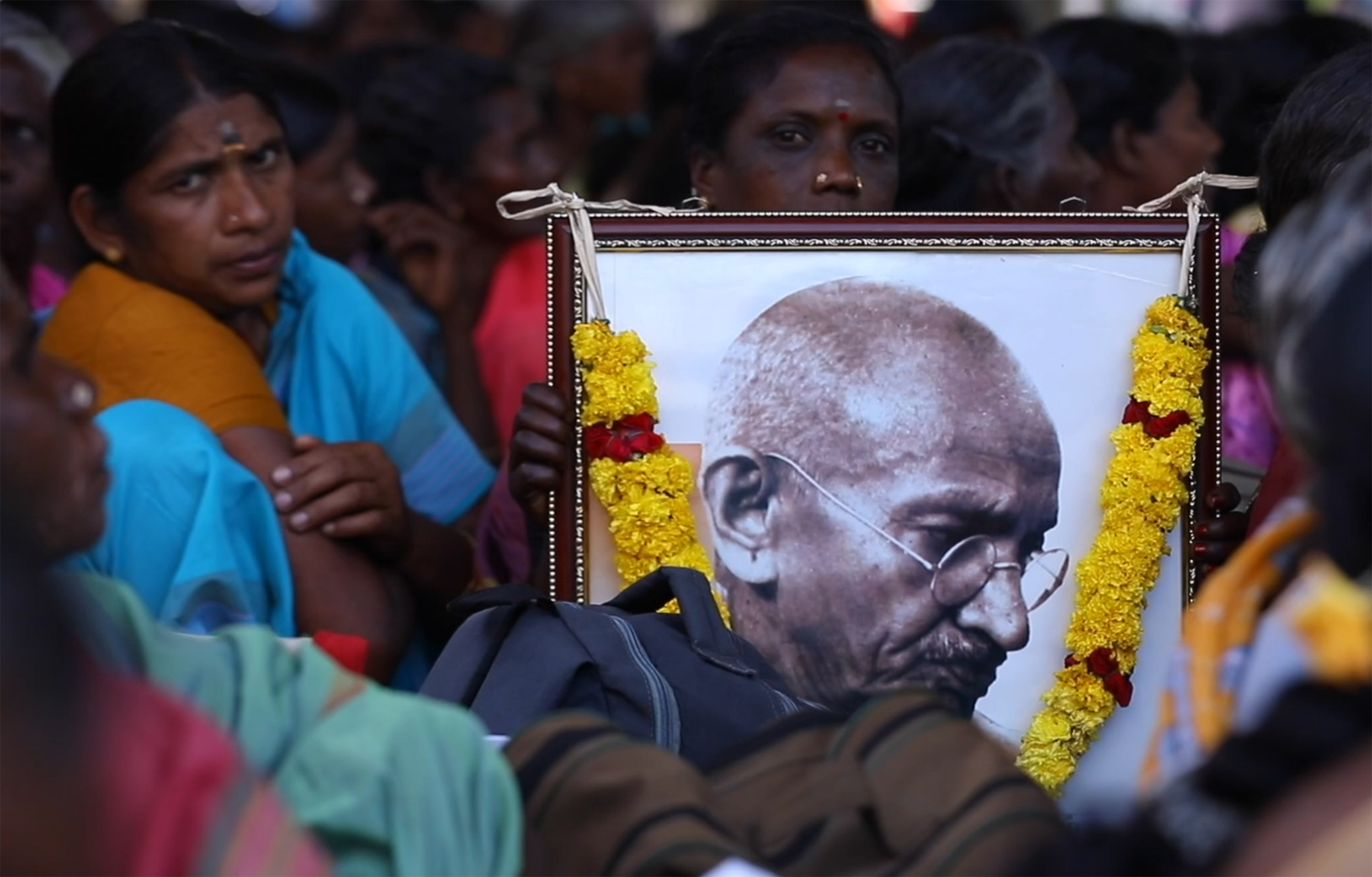 Protesters holding an image of Gandhi