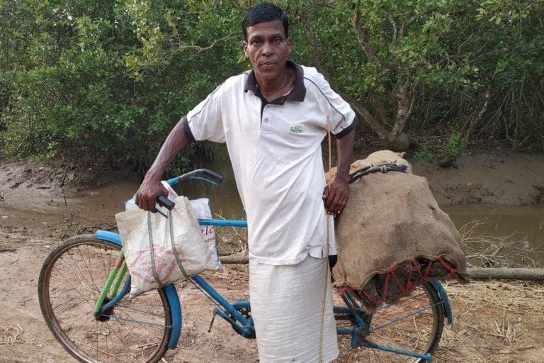 Man carrying a sack of cow dung cakes to be used as fuel