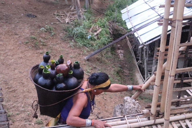 A woman carries containers on her back