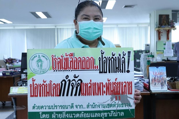 woman wearing a mask holds a sign