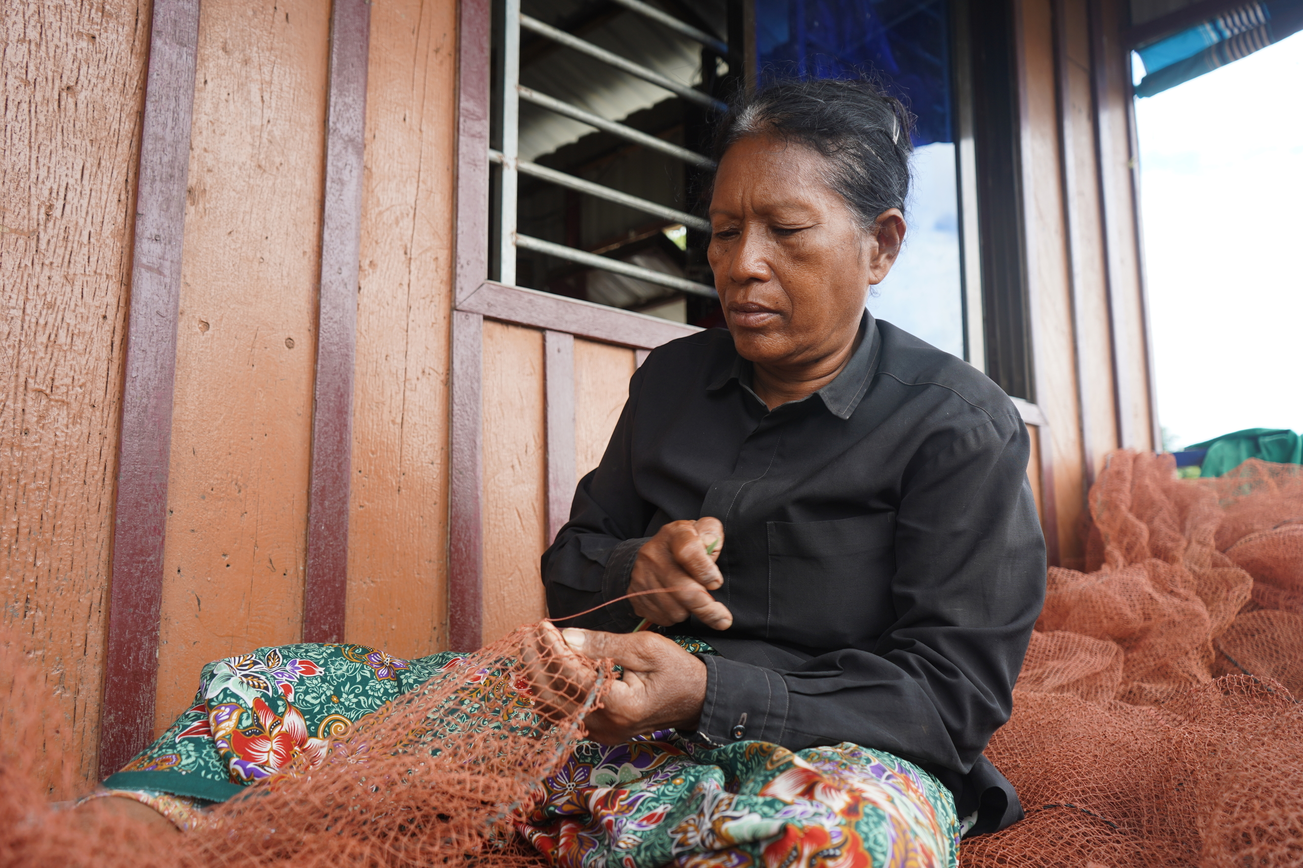 woman mending a fishing net