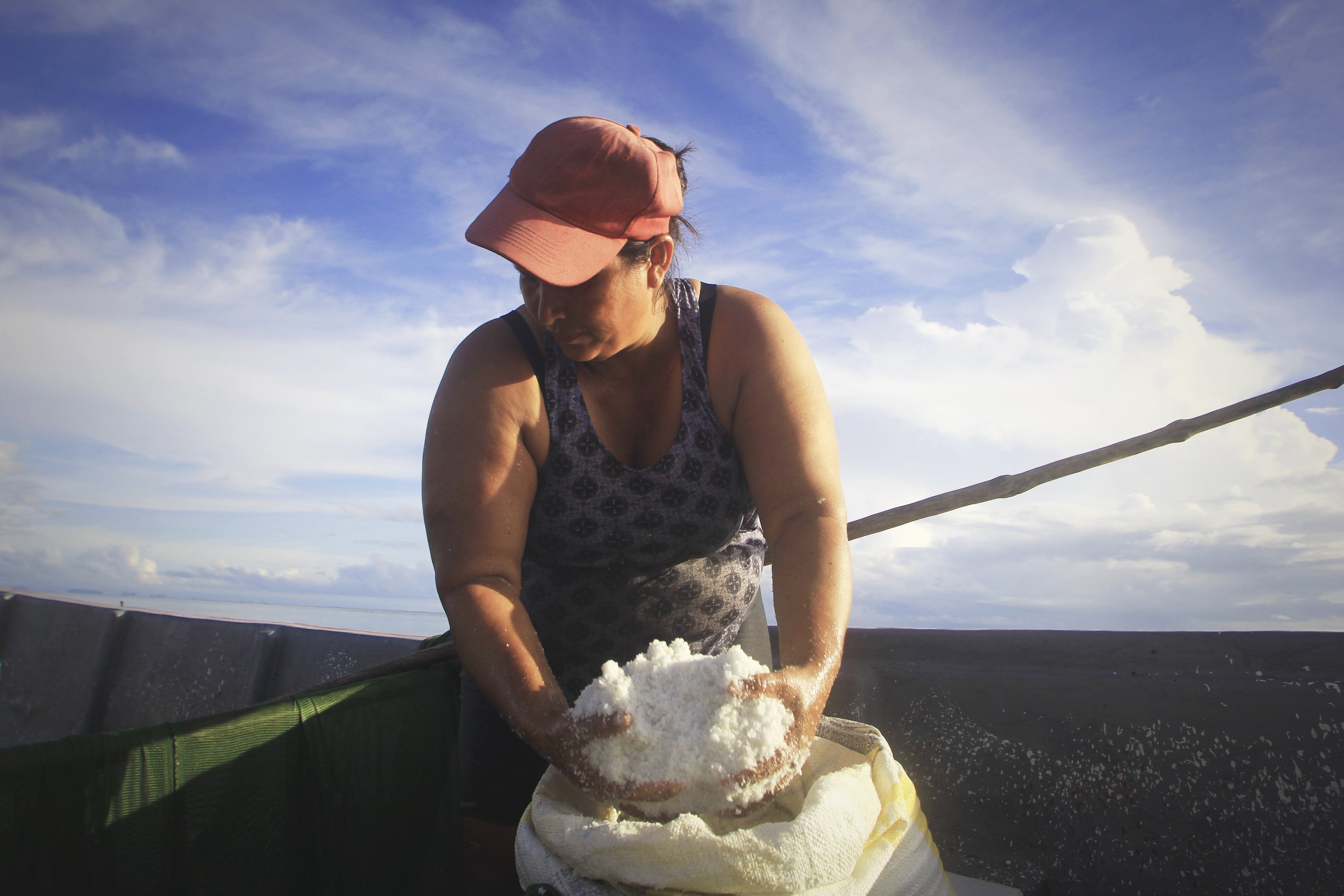 a woman spreads salt on the catch