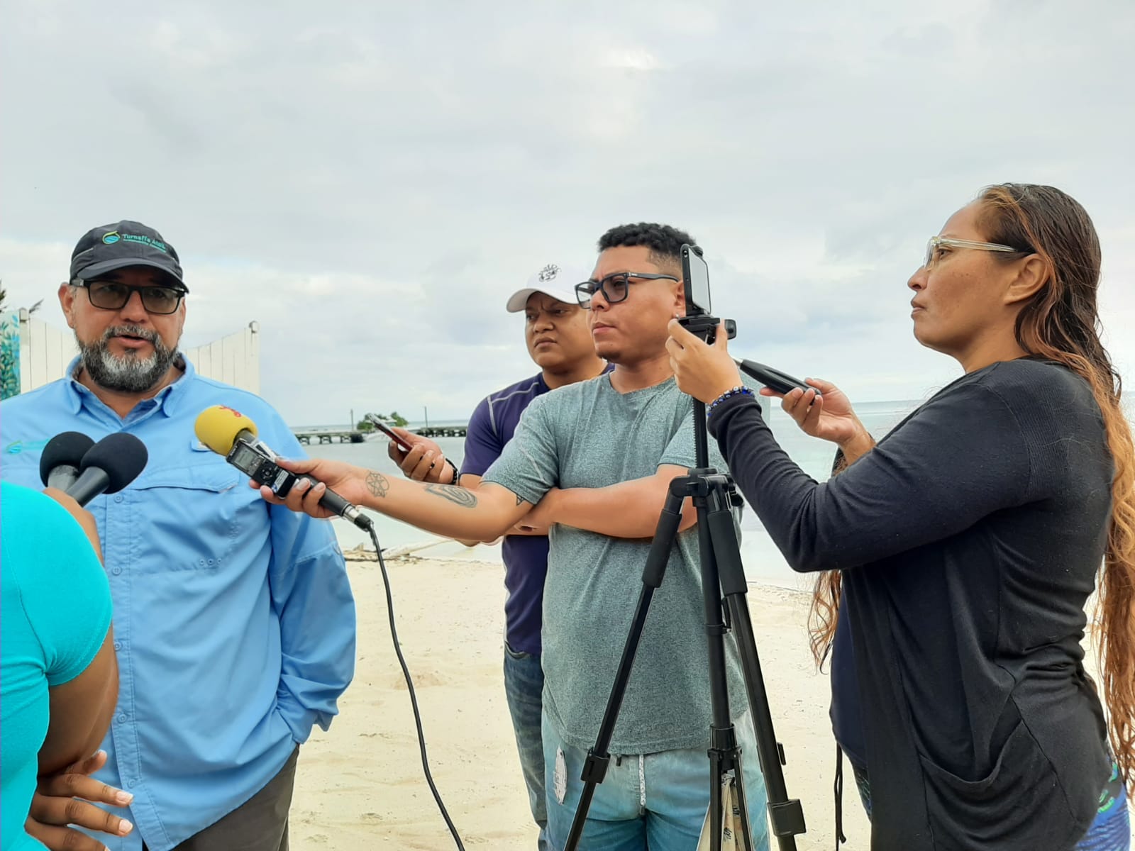 journalists interview a man on a beach