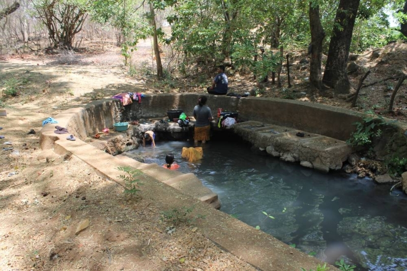people washing clothes in a pond