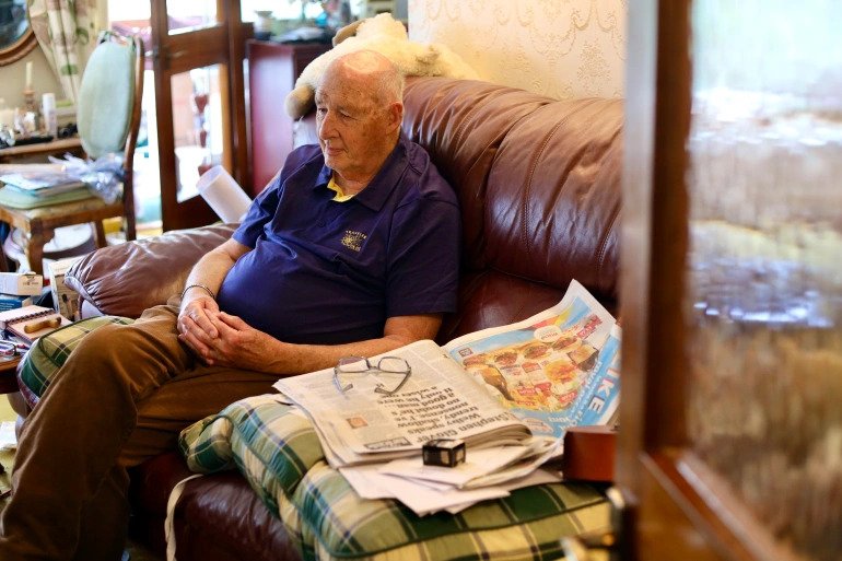 Peter MacDonald, Swale Borough councillor, 81, in his home. He inherited the passion for coastal matters from his father and dedicated his life to engaging with local residents calling for the renewal of the area’s failing sea defences [Gaia Lamperti/Al Jazeera]