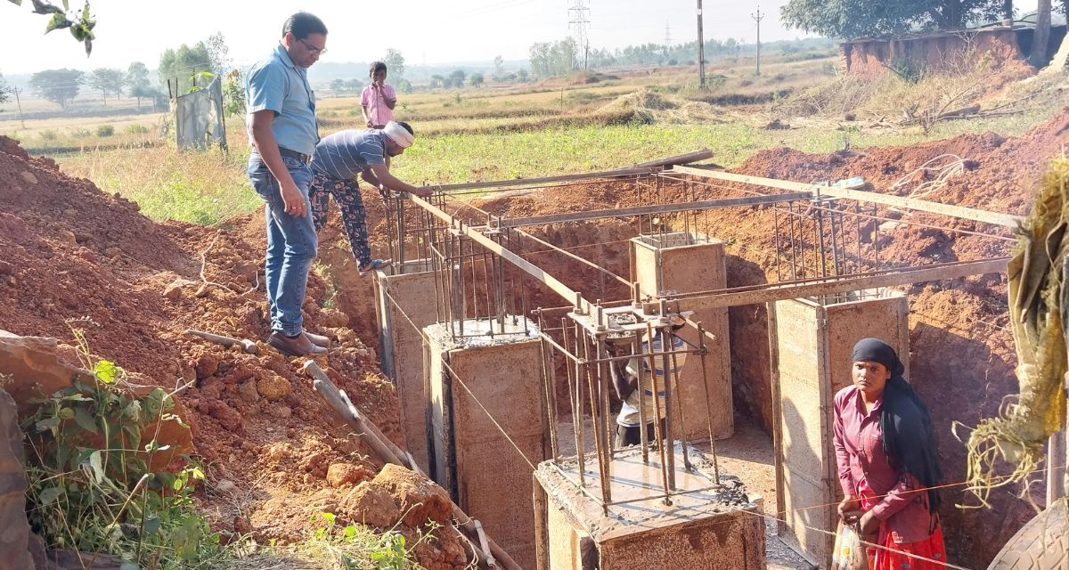 A man inspects the construction of a foundation in the ground