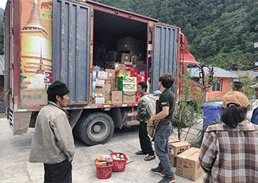 people standing near a truck with the back open and you can see boxes of food inside