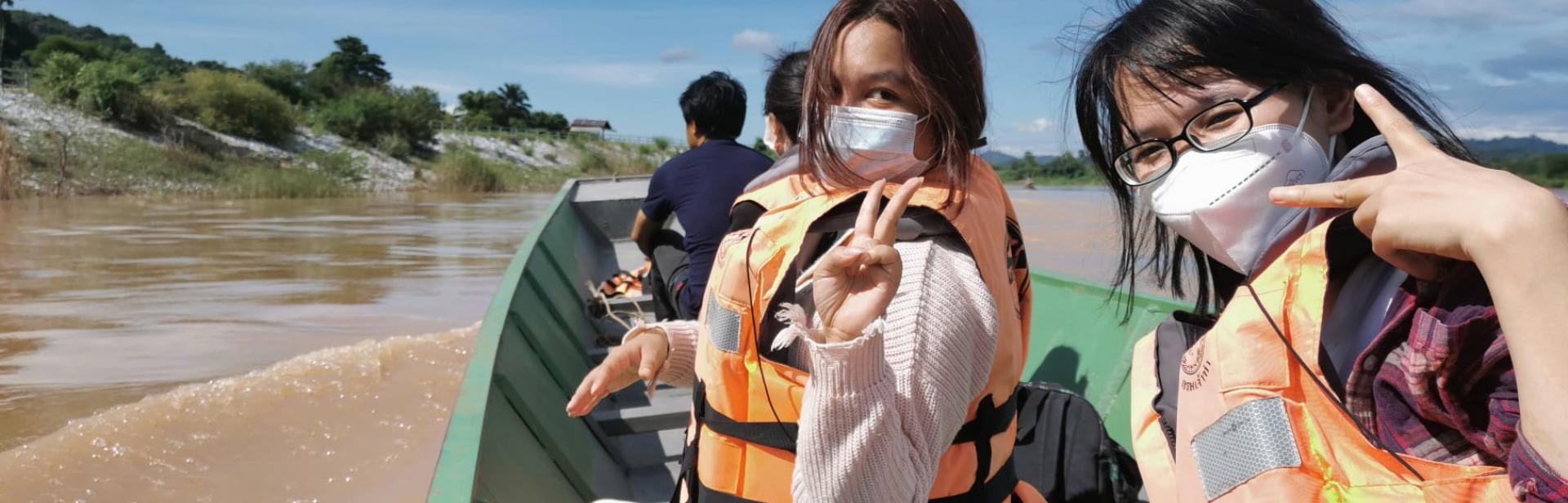 journalists wearing life jackets on a boat