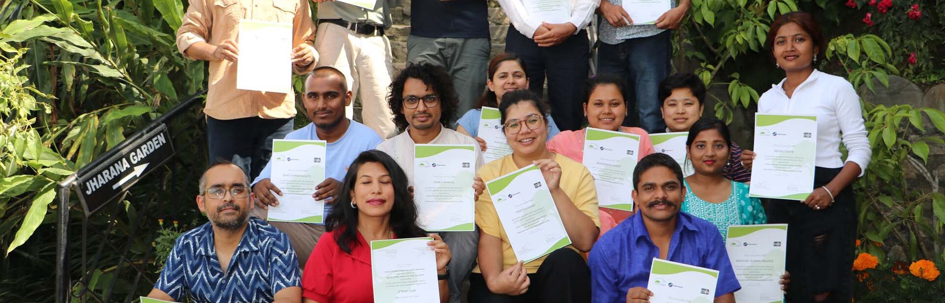 Participants look at the camera holding up certificates