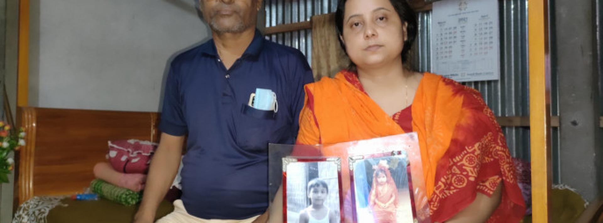 a man and woman face the camera holding two photographs