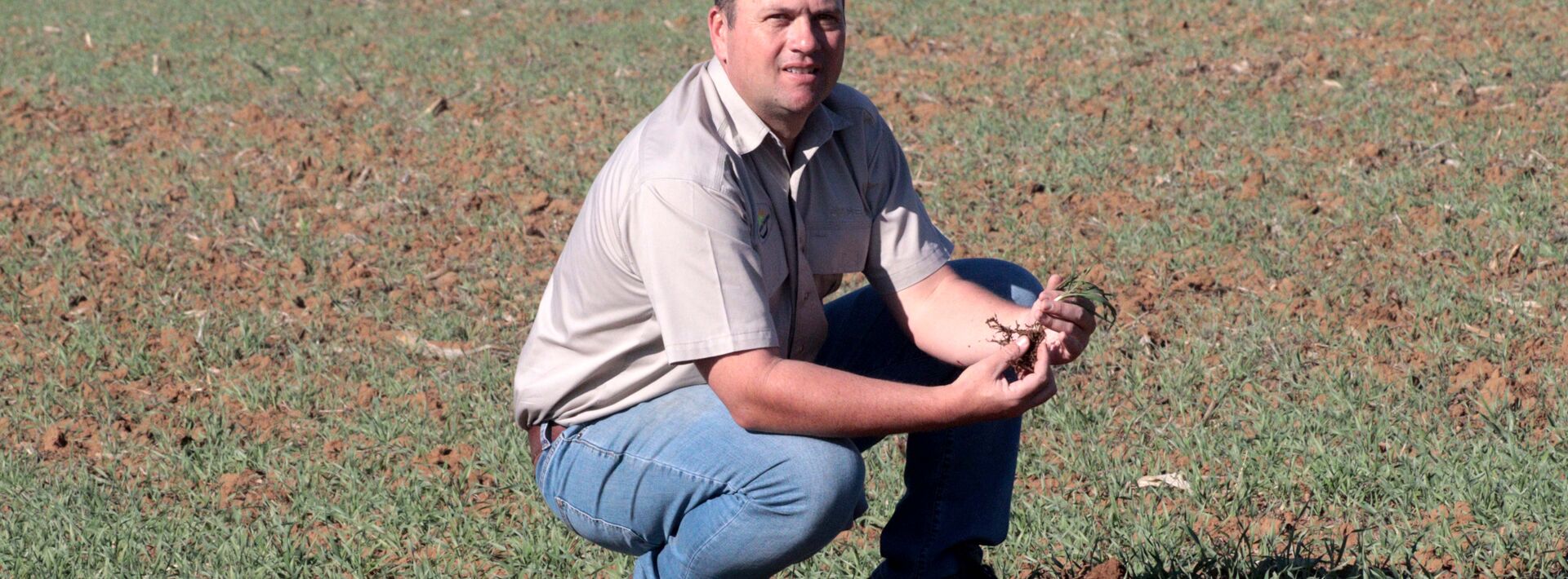 A farmer inspects the quality of his soil 