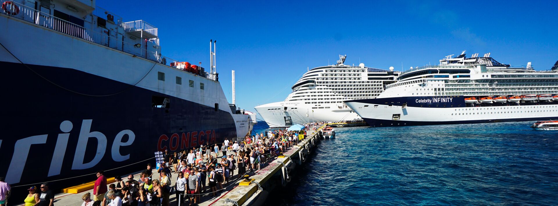people boarding onto a cruise ship at port in cozumel
