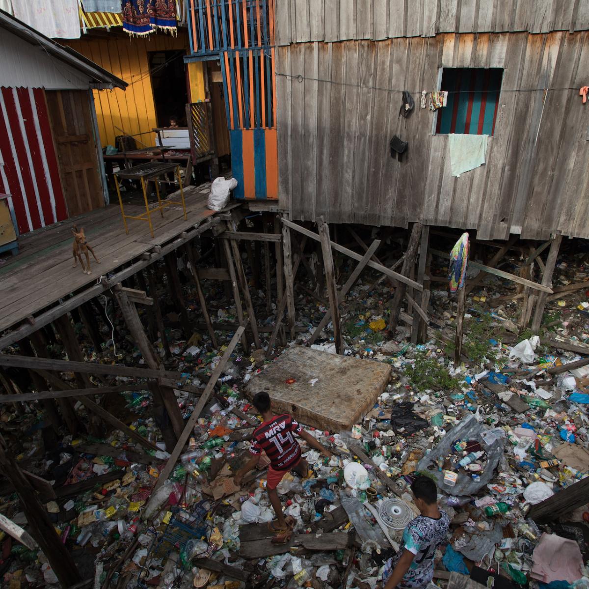 Stilted houses over garbage washed in from Educandos Creek / Credit: Bruno Kelly