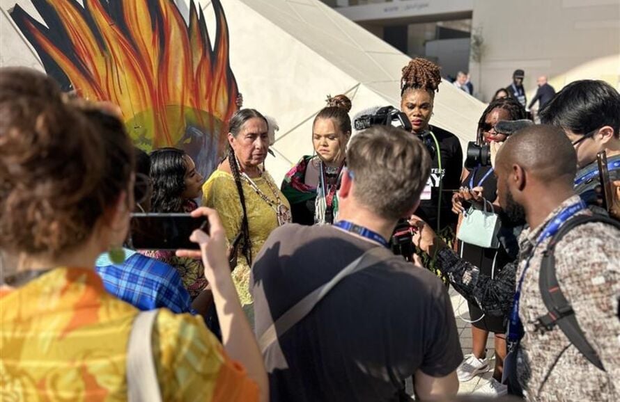 Journalists photograph and interview an Indigenous protest at COP28