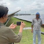 a woman photographs a man near solar panels 
