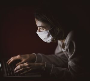 Masked woman on a computer