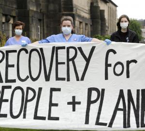 a banner of people protesting in the streets for green recovery