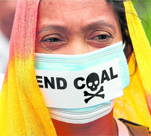 Woman in mask calling to end coal. 