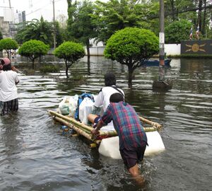 people carry their belongings on a raft in a flood. 