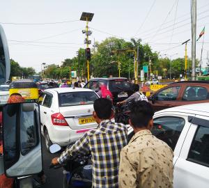 a busy street with cars and two-wheelers in Indore