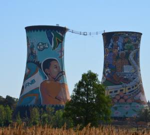 two cooling towers with street art