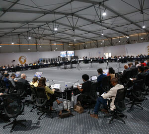 a large, brightly lit conference room full of people sitting in chairs
