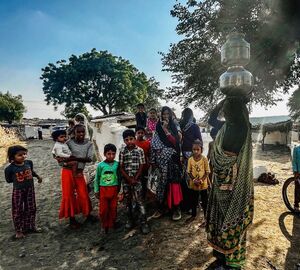 Women and children surround a tribal woman getting ready to fetch water from a nearby well in Khiriya Bharka village of Ashoknagar district, Madhya Pradesh in October 2022/ Credit: Tarushi Aswani.