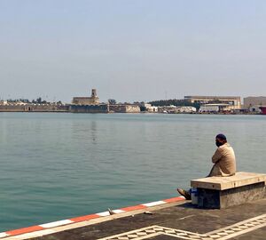a man sitting on the edge of the dock at the port of veracruz