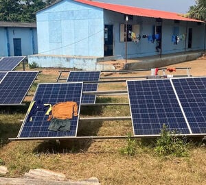 clothes drying on solar panel outdoors in front of blue building 