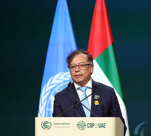 Colombian President Gustavo Petro stands at a podium with the United Nations and United Arab Emirates flags behind him.