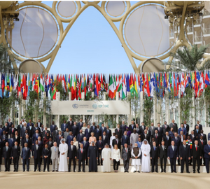 a large group of people standing in front of international flags